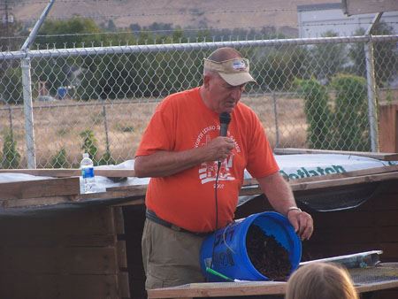 Workshop Presenter Dumping Soil from a Blue Bucket